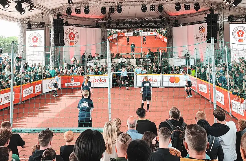 Aufmerksame Zuschauer beim Bundesfinale der Soccer Liga auf Rügen beobachten gespannt ein Fußballspiel